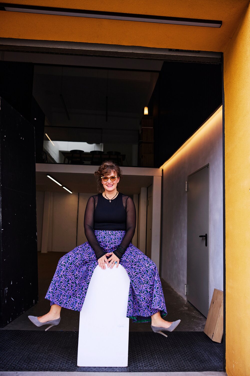 Paulina sitting in a yellow doorway