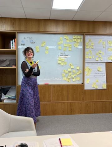 Paulina at a whiteboard covered in sticky notes