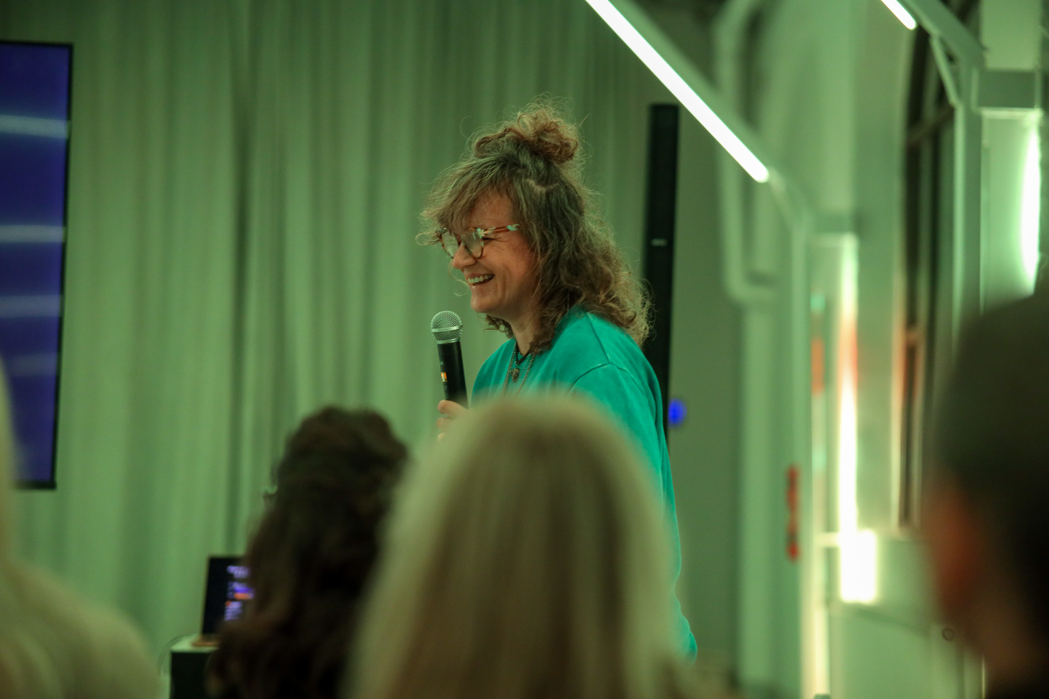 Paulina speaking to an audience with a microphone